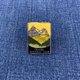 Pin with glacier national park mountain design on a denim background