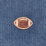 Glittery football-shaped patch on denim fabric