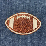 Glittery football-shaped patch on denim fabric