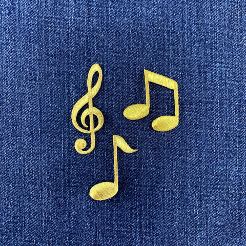 gold note and G clef patches on a denim background