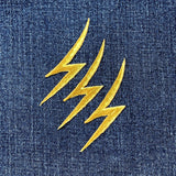 3 Gold lightning bolt patches on blue denim fabric