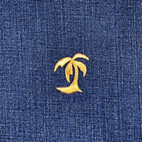 Gold palm tree patch on blue denim fabric
