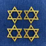 4 gold star of David patches on a denim background