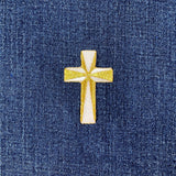 Gold cross patch on blue denim fabric