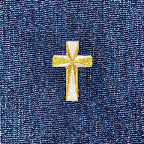 Gold cross patch on blue denim fabric