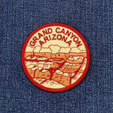 Embroidered circular patch depicting a stylized view of the Grand Canyon in Arizona, with the words "GRAND CANYON ARIZONA" stitched around the red border.