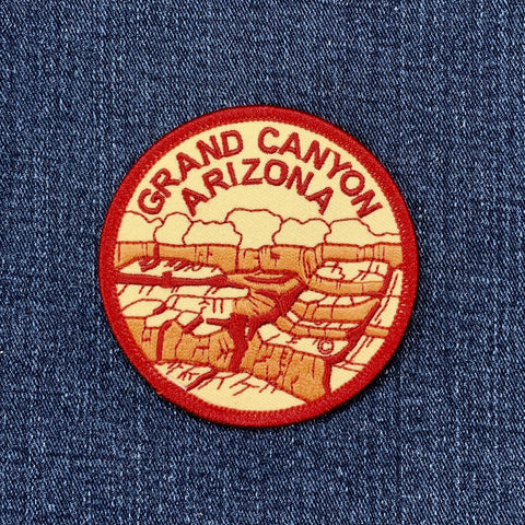 Embroidered circular patch depicting a stylized view of the Grand Canyon in Arizona, with the words "GRAND CANYON ARIZONA" stitched around the red border.