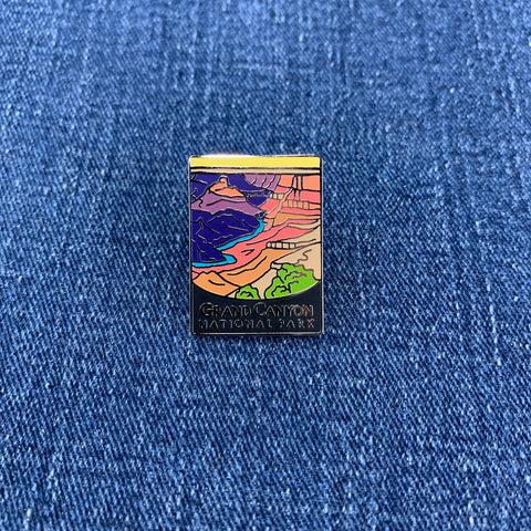 Colorful enamel pin of Grand Canyon National Park on a blue denim background