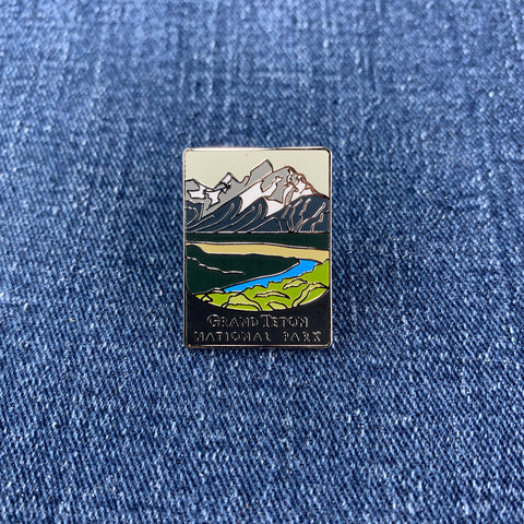 Pin with Grand Teton National Park design on a blue denim background