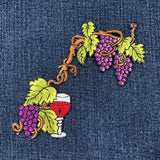 Embroidered design of grapes and a wine glass on denim fabric