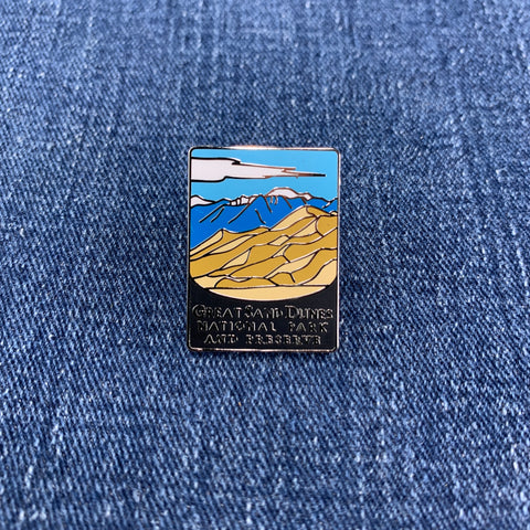 Pin with a great sand dunes national park mountain and desert design on a blue denim background