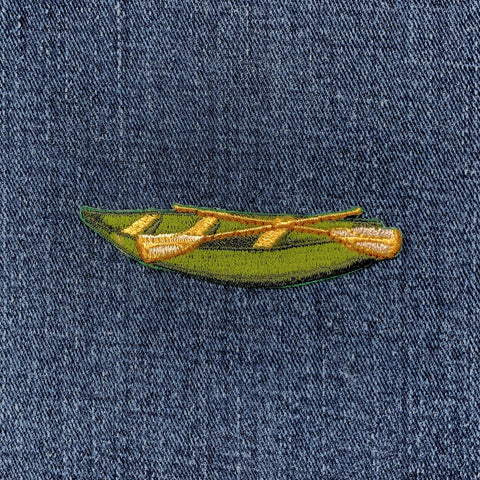 Embroidered green canoe patch on denim fabric