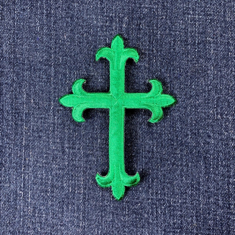 Green cross-shaped patch on a blue denim background