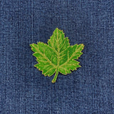 Green leaf patch on blue denim fabric