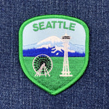 Embroidered patch with Seattle landmarks on a denim background