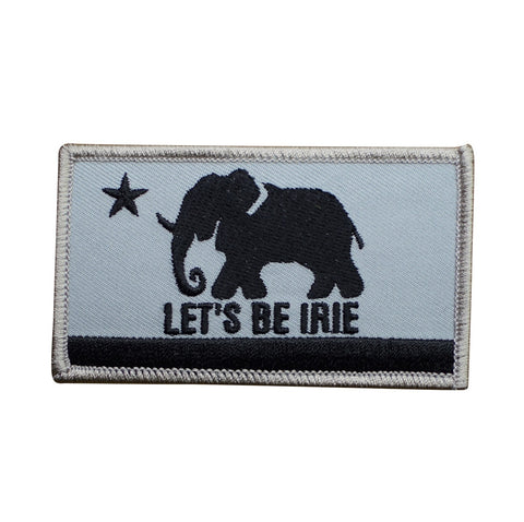 An embroidered rectangular patch featuring a black elephant silhouette, a black star, and the text 'LET'S BE IRIE' on a light gray background with a black horizontal stripe and gray stitched border.