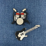 Embroidered patches of a drum set and a guitar on denim fabric.