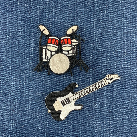 Embroidered patches of a drum set and a guitar on denim fabric.