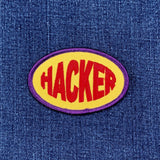 Patch with 'HACKER' text on a blue denim background