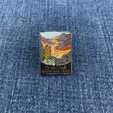 A pin badge featuring an illustration of a stream and mountains with the text 'Haleakala National Park' on a denim background