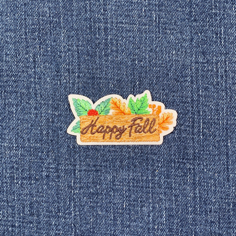 Embroidered patch with 'Happy Fall' text on a denim background