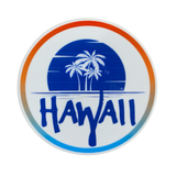 A circular sticker with a white background and a gradient border of orange, blue, and white. The center design features a dark blue sunset/ocean scene with the white silhouette of three palm trees, and the word 'HAWAII' written in large, brush-style dark blue letters across the bottom.
