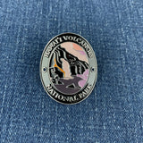 A round enamel Walking Stick Medallion featuring Hawaii Volcanoes National Park, displayed on a blue denim background.