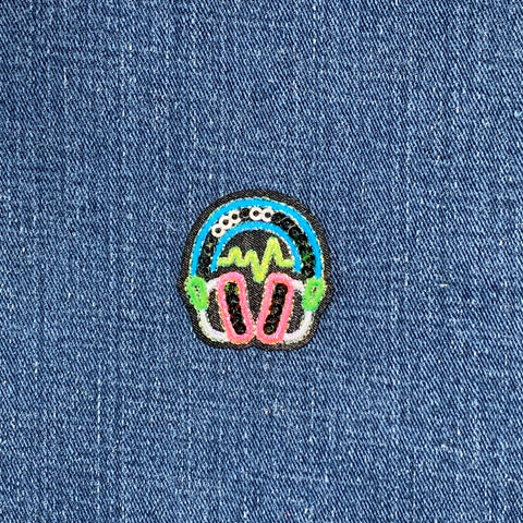 Colorful patch with headphones and heartbeat design on a denim background