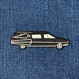 Embroidered patch of a hearse on denim fabric