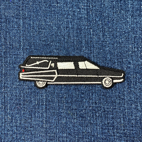 Embroidered patch of a hearse on denim fabric