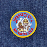 A round embroidered patch featuring the Hearst Castle with text 'Hearst Castle San Simeon, Calif.' on a denim background