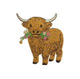 An embroidered patch of a Highland cow with brown fur, curved horns, and a floral collar, shown on a plain white background.