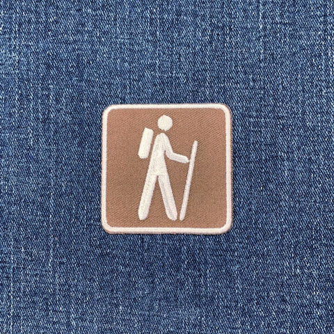 Embroidered hiking patch on denim fabric