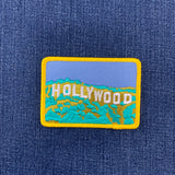 Embroidered patch with 'Hollywood' text on a blue denim background
