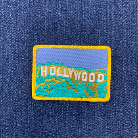 Embroidered patch with 'Hollywood' text on a blue denim background