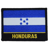 Embroidered patch of the flag of Honduras, featuring two blue bands and a central white band with five blue stars. The word "HONDURAS" is stitched in yellow on a black border below the flag.