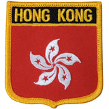 An embroidered souvenir badge featuring the text 'HONG KONG' along with the flag symbol of Hong Kong, bordered in yellow, with a hook at the back for ironing on.