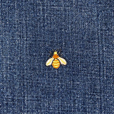 Embroidered bee patch on blue denim fabric