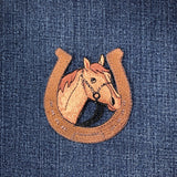 Embroidered patch of a horse head and horseshoe on denim fabric