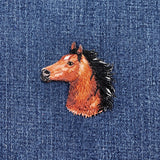 Embroidered horse head patch on denim fabric