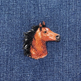 Embroidered horse head patch on denim fabric