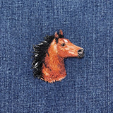 Embroidered horse head patch on denim fabric