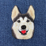 Embroidered patch of a husky dog's face on denim fabric