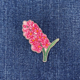 Pink hyacinth flower patch on denim fabric