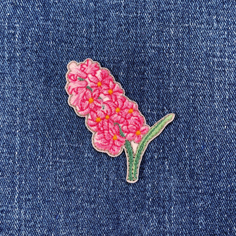 Pink hyacinth flower patch on denim fabric