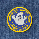 Round blue patch with a smiling ghost character, text 'FRIENDLIEST GHOST TOWN HYDER, ALASKA', and a yellow embroidered border on a denim background