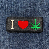 Patch with 'I heart cannabis leaf' symbol and cannabis leaf on denim fabric