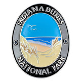 An oval walking stick medallion with an illustration of a beach and Lake Michigan, and the text 'Indiana Dunes National Park' 