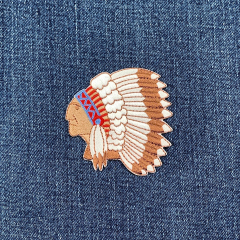 Embroidered patch of a Native American headdress on denim fabric