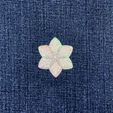 Snow-shaped iridescent patch on a denim background